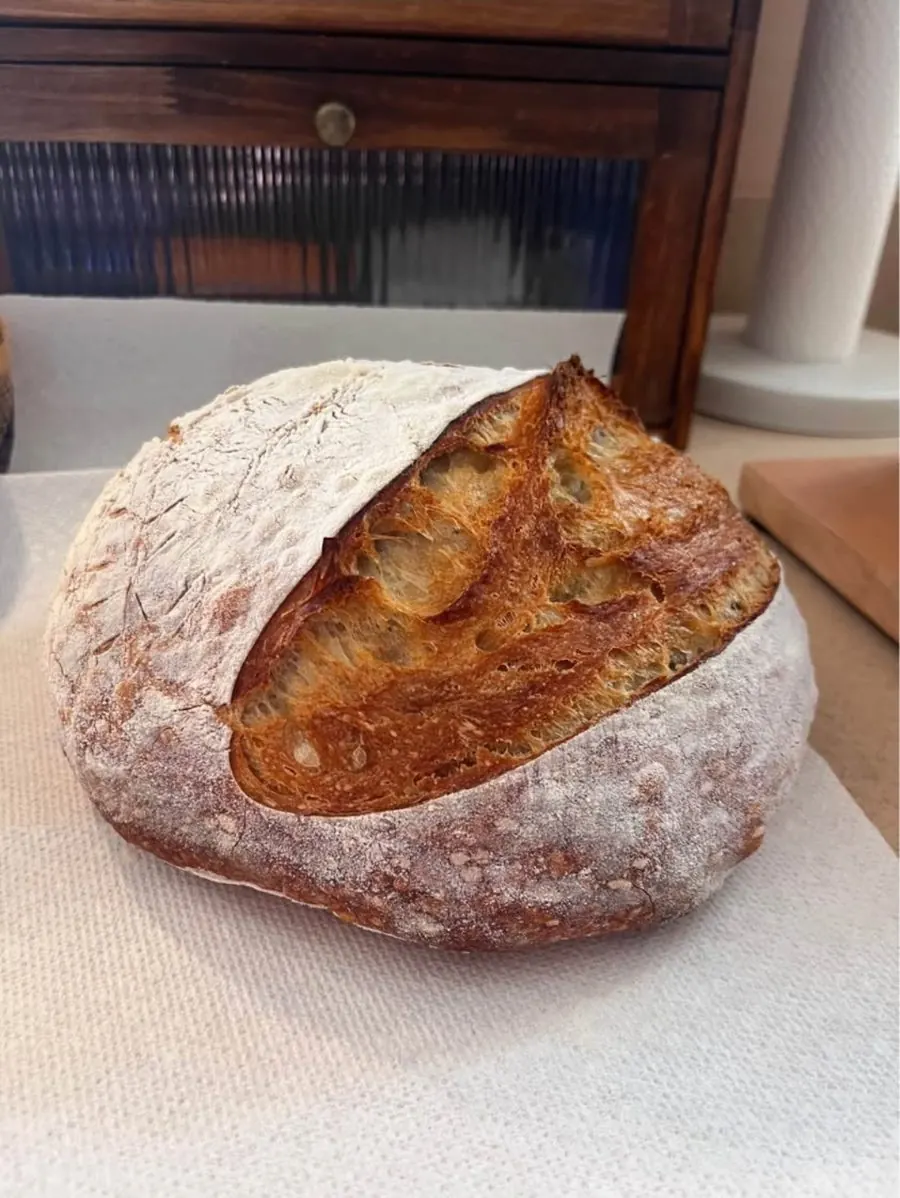 Floured sourdough loaf with one long scored ear
